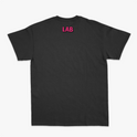 Camiseta com estampa frontal de cruz contendo a frase "Lugar abençoado" e símbolo decorativo, e estampa traseira de texto "LAB" em destaque.