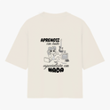 Camiseta com estampa frontal de personagem relaxado e estampa traseira de frase "Aprendiz em tudo, especialista em nada" com instrumentos e computador.