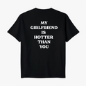 Camiseta com estampa traseira de frases em destaque: "MY GIRLFRIEND IS HOTTER THAN YOU", distribuídas em quatro linhas com uma tipografia marcante.
