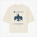 Camiseta com estampa frontal de pássaro estilizado, frases sobre masculinidades, "SÃO TRANSCESTRAIS" e "BRASIL - BAHIA"; estampa traseira de símbolo tribal.