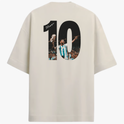 Camiseta com estampa traseira de número grande "10" ilustrando jogador em ação segurando troféu, com assinatura sobreposta e multidão ao fundo.