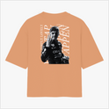 Camiseta com estampa frontal de um logotipo e nome em tamanho pequeno e estampa traseira de um piloto em ação com texto estilizado ao fundo.