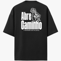 Camiseta com estampa frontal de chaves cruzadas e estampa traseira de mão segurando chave, junto com a frase "Abre Caminho o sentinela está na porta".