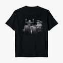 Camiseta com estampa frontal de pequeno logotipo discreto e estampa traseira de fotografia em preto e branco de carro de corrida com texto sobreposto.