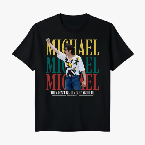 Camiseta com estampa frontal de retrato de artista posando com óculos e camisa decorada, sobreposto ao nome repetido em blocos grandes, e frase adicional.