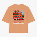 Camiseta com estampa traseira de carro vintage estilizado, com destaque para faróis e grade frontal, acompanhada da palavra "VINTAGE" e padrão quadriculado.