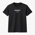 Camiseta com estampa frontal de texto em destaque "OBSESSED" em letras maiúsculas, acompanhada por pequenos detalhes e marcas registradas abaixo.