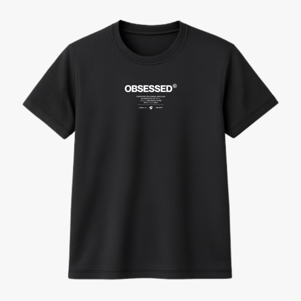 Camiseta com estampa frontal de texto em destaque "OBSESSED" em letras maiúsculas, acompanhada por pequenos detalhes e marcas registradas abaixo.