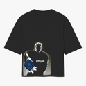 Camiseta com estampa frontal de personagem estilizado segurando um passaporte com a palavra "pega" em destaque logo abaixo, criando um design expressivo.