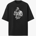 Camiseta com estampa frontal de um cantor segurando um microfone, exibindo detalhes de uma jaqueta e um nome logo abaixo em fonte estilizada.