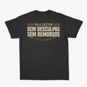 Camiseta com estampa frontal de um emblema pequeno com a palavra "VALA" e estampa traseira com texto "VALA KUSTOM SEM DESCULPAS SEM REMORSOS" e detalhes geométricos.