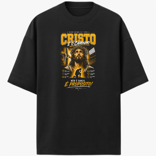 Camiseta com estampa frontal de uma figura religiosa cercada por textos e elementos gráficos detalhados, incluindo frases em destaque e simbologia variada.