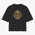 Camiseta com estampa frontal de emblema oval contendo texto "ATHOS", ferramentas, bigode, tesouras e barba, com detalhes e ornamentos circulares.