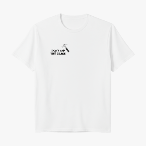 Camiseta com estampa frontal de martelo e texto "Don't Tap The Glass" e estampa traseira de rosto com boné, texto e blocos coloridos ao lado.