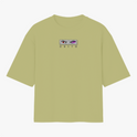 Camiseta com estampa frontal de olhos intensos e nome em destaque, e estampa traseira de personagem estilizado com texo, figuras geométricas e ilustrações.