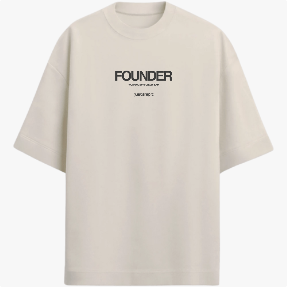 Camiseta com estampa frontal de texto em três partes: "FOUNDER" no topo, "WORKING 24/7 FOR A DREAM" no centro e "justshipit" na base.