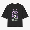 Camiseta com estampa frontal de guaxinim segurando um copo, acompanhada da frase "FIRST COFFEE THEN CHAOS" em estilo tipográfico destacado.