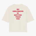 Camiseta com estampa traseira de texto incisivo em letras maiúsculas que declara "MY GIRLFRIEND IS HOTTER THAN YOU" em estilo direto e ousado.