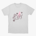 Camiseta com estampa frontal de personagens ao lado de pinheiro estilizado, acompanhados por flocos de neve dispersos pelo design.