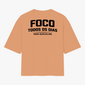 Camiseta com estampa frontal de texto “IRON DISCIPLINE” estilizado e, na estampa traseira, texto “FOCO TODOS OS DIAS” em negrito com “IRON DISCIPLINE”.