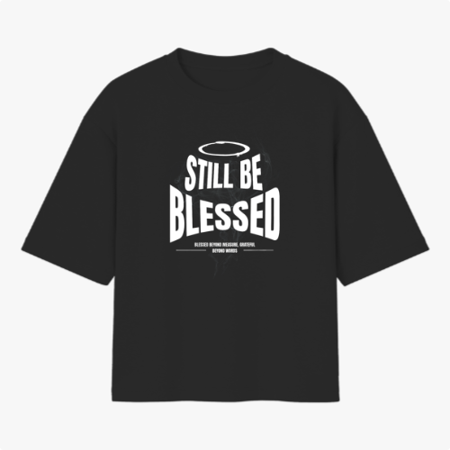 Camiseta com estampa frontal de texto 'Still Be Blessed' acompanhado de um halo, e estampa traseira de texto estilizado 'God is Good'.