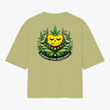 Camiseta com estampa frontal de rosto sorridente decorado com folhas e texto "Elevate Your Frequency" emoldurado por elementos naturais e estampa traseira de símbolo geométrico simples próximo à gola.
