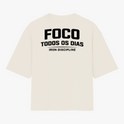 Camiseta com estampa frontal de texto “IRON DISCIPLINE” estilizado e, na estampa traseira, texto “FOCO TODOS OS DIAS” em negrito com “IRON DISCIPLINE”.