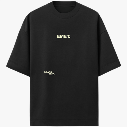 Camiseta com estampa frontal de "EMET." e "BRASIL 2026." e estampa traseira de emblema com "EMET.", estrelas e citação sobre cultura e vida.