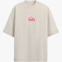 Camiseta com estampa frontal de "lab" em letras vibrantes e detalhes de linhas onduladas, e estampa traseira de "God is Good" sobrepondo um círculo.