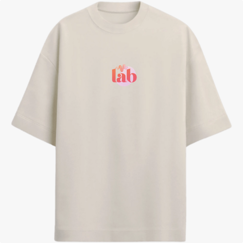 Camiseta com estampa frontal de "lab" em letras vibrantes e detalhes de linhas onduladas, e estampa traseira de "God is Good" sobrepondo um círculo.
