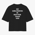 Camiseta com estampa traseira de texto incisivo em letras maiúsculas que declara "MY GIRLFRIEND IS HOTTER THAN YOU" em estilo direto e ousado.