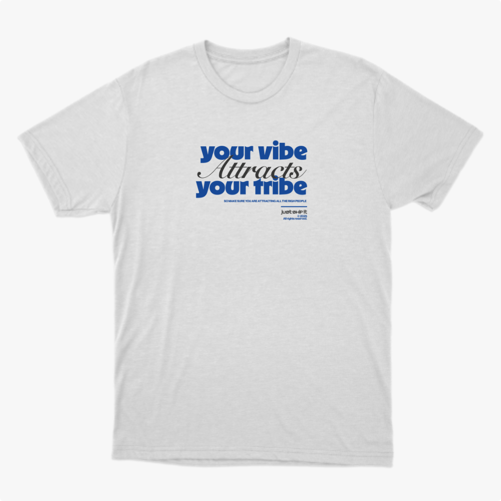 Camiseta com estampa frontal de frase inspiradora em fontes diversas, destacando "your vibe attracts your tribe," com pequenos detalhes textuais adicionais.