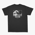 Camiseta com estampa traseira de onda dividida em três painéis, acompanhada do texto "TOKYO 1986" e caracteres japoneses abaixo.