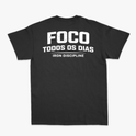 Camiseta com estampa frontal de "IRON Discipline" com halteres e estampa traseira de "FOCO TODOS OS DIAS" sobre "IRON DISCIPLINE" em letras destacadas.