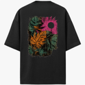 Camiseta com estampa frontal de pequeno logotipo minimalista e estampa traseira de folhas tropicais em diversas cores e círculo texturizado.