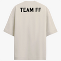 Camiseta com estampa frontal de texto estilizado "TïFF" e estampa traseira de "TEAM FF" em letras maiúsculas.