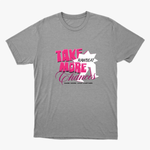 Camiseta com estampa frontal de texto estilizado "Take More Chances" sobreposto a uma estrela, acompanhado de frases menores complementares.