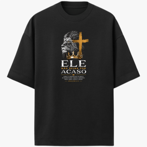 Camiseta com estampa frontal de leão em perfil ao lado de uma cruz, seguida pela frase "Ele não reina por acaso" e texto menor detalhando uma passagem.