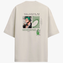 Camiseta com estampa frontal de pequeno logotipo estilizado e estampa traseira de personagem em quadrinhos com frase em destaque e elementos gráficos.