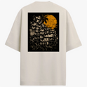 Camiseta com estampa frontal de pequeno logotipo circular minimalista no canto inferior esquerdo e estampa traseira de favela sob enorme sol amarelo texturizado.