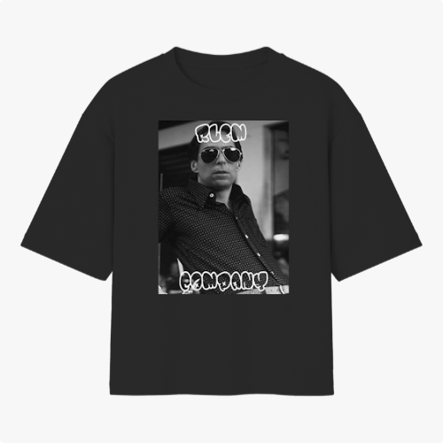 Camiseta com estampa frontal de fotografia em preto e branco de uma pessoa usando óculos escuros, com texto estilizado acima e abaixo da imagem.