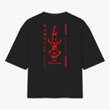 Camiseta com estampa frontal de um emblema circular detalhado em preto e vermelho e estampa traseira de espada estilizada com texto em japonês em vermelho.