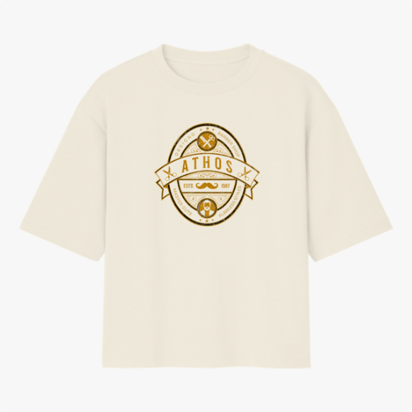 Camiseta com estampa frontal de emblema oval contendo texto "ATHOS", ferramentas, bigode, tesouras e barba, com detalhes e ornamentos circulares.