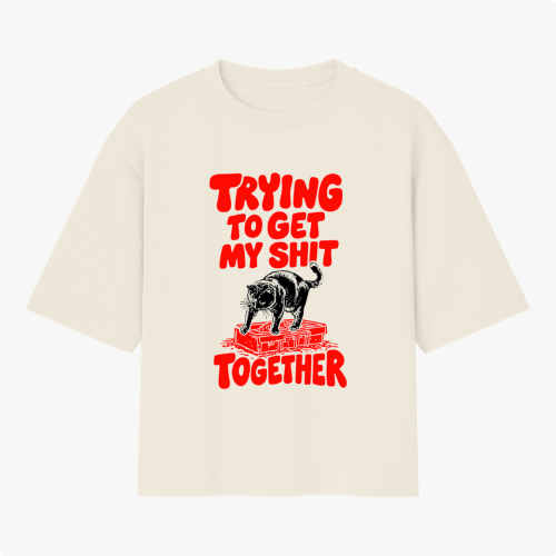 Camiseta com estampa frontal de um urso sobre blocos de construção com a frase em destaque "Trying to Get My Shit Together" em letras estilizadas.