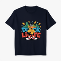 Camiseta com estampa frontal de pato estilizado em pose confiante, rodeado por moedas douradas, edifícios verdes e as palavras "Duck Life" em azul e vermelho.