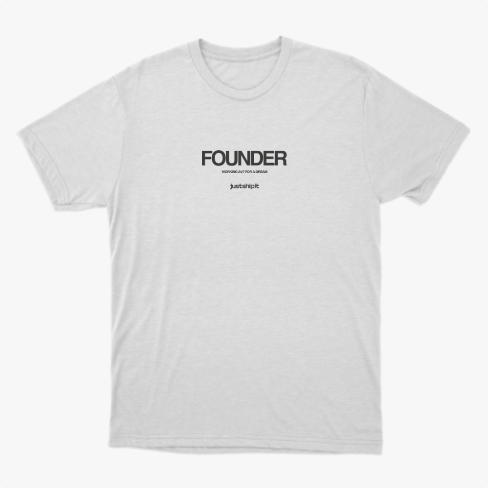 Camiseta com estampa frontal de texto "FOUNDER" em destaque, acompanhada pela frase "WORKING 24/7 FOR A DREAM" e logotipo "justshipit" abaixo.