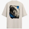 Camiseta com estampa frontal de pequeno símbolo circular com seta apontando para cima no lado esquerdo do peito e estampa traseira de surfista em túnel de onda dinâmica com efeitos de pinceladas.