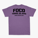Camiseta com estampa frontal de "IRON Discipline" com halteres e estampa traseira de "FOCO TODOS OS DIAS" sobre "IRON DISCIPLINE" em letras destacadas.