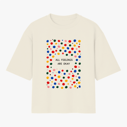 Camiseta com estampa frontal de padrão de bolinhas coloridas ao redor da frase central "ALL FEELINGS ARE OKAY", criando um visual vibrante e acolhedor.