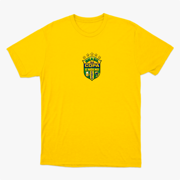 Camiseta com estampa frontal de brasão com cinco estrelas acima e frases "BRASIL NA COPA" e "E NÓS NO SOFÁ", acompanhado de duas bandeiras na lateral.